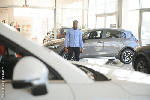 Car Buyer. Black Guy Choosing New Automobile In Dealership Store