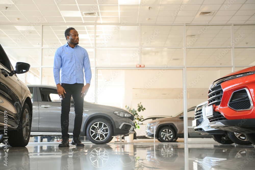 His dream car. Happy young African man looking excited choosing a car at the dealership His dream car. Happy young African man looking excited choosing a car at the dealership