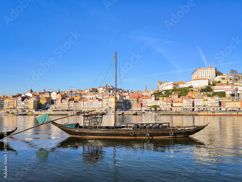 Embarcação tradicional em águas do Douro na Ribeira em Vila Nova de Gaia, com a velha cidade ao horizonte photo