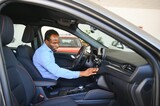 Car Owner. Joyful Afro Guy Smiling, Sitting In New Automobile Driving From Dealership Shop