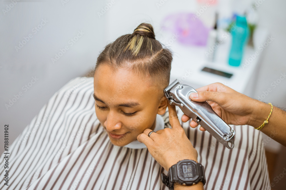barber's hand shaving asian male customer hair using electric shaver barber's hand shaving asian male customer hair using electric shaver