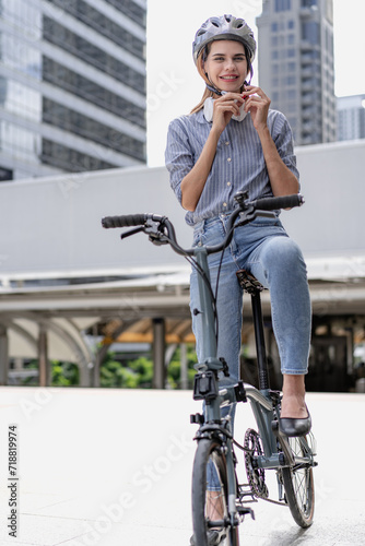 Confident businesswoman ride bicycle outside in downtown. Environmental conservation person commuting by cycling reduce carbon footprint. Bile to work, eco friendly alternative vehicle to green energy