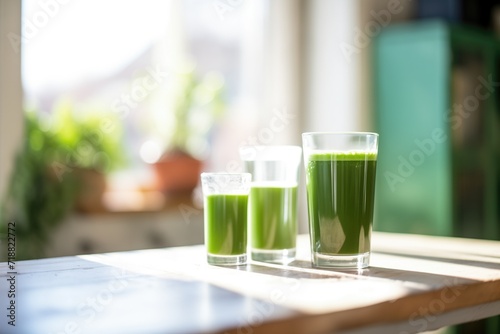 cold glass of green juice with morning dew, sunlight behind