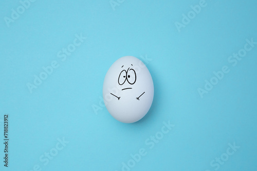 Surprised egg isolated on the blue background. Copy space. Emoticons concept. Art collage