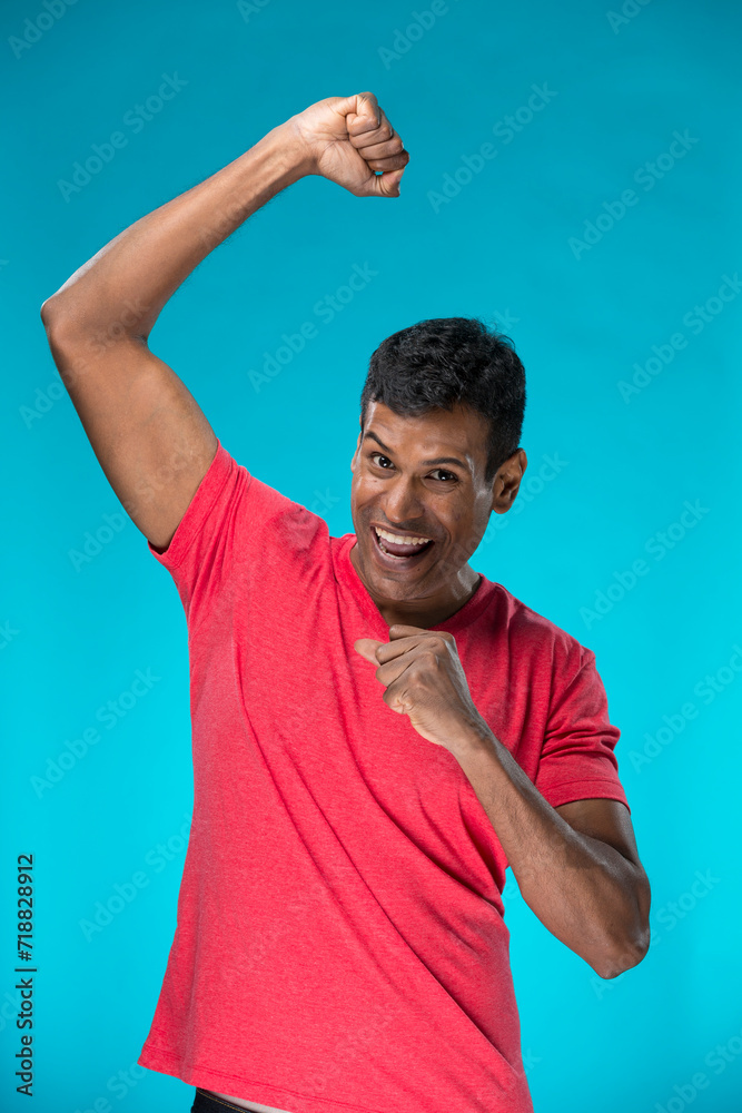 Indian man celebrating with his arm up. Indian man celebrating with his arm up.