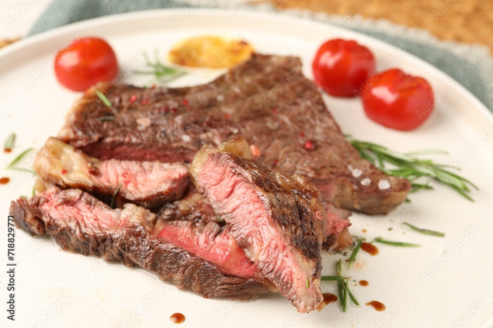 Delicious grilled beef steak, tomatoes and rosemary on plate, closeup