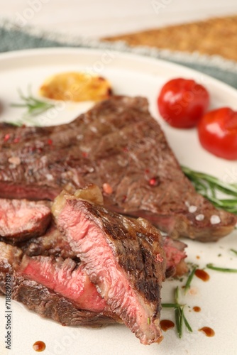 Delicious grilled beef steak, tomatoes and rosemary on plate, closeup