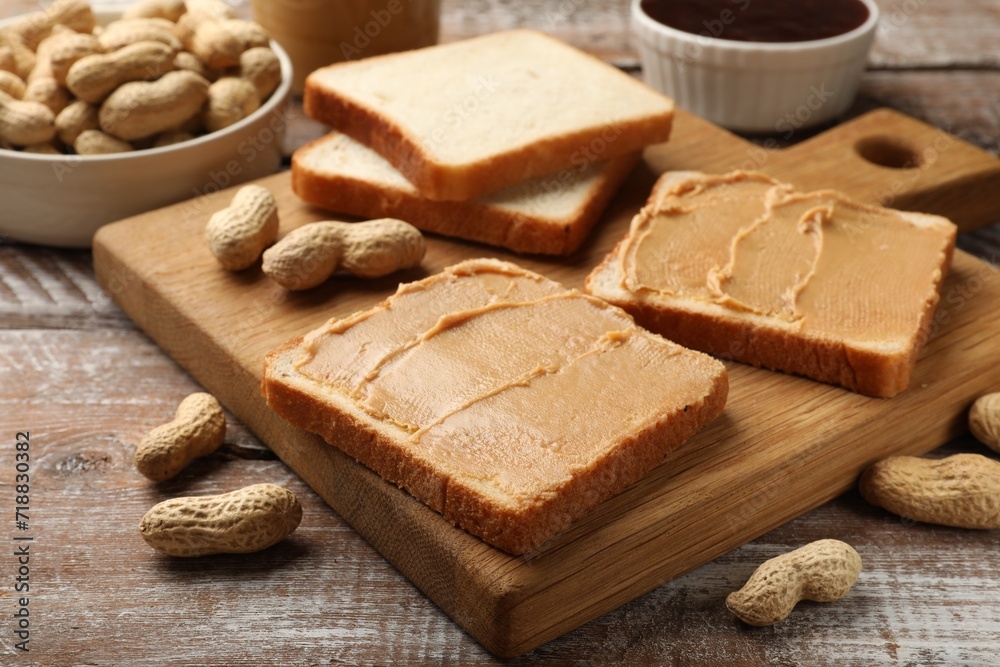 Tasty peanut butter sandwiches and peanuts on wooden table, closeup Tasty peanut butter sandwiches and peanuts on wooden table, closeup