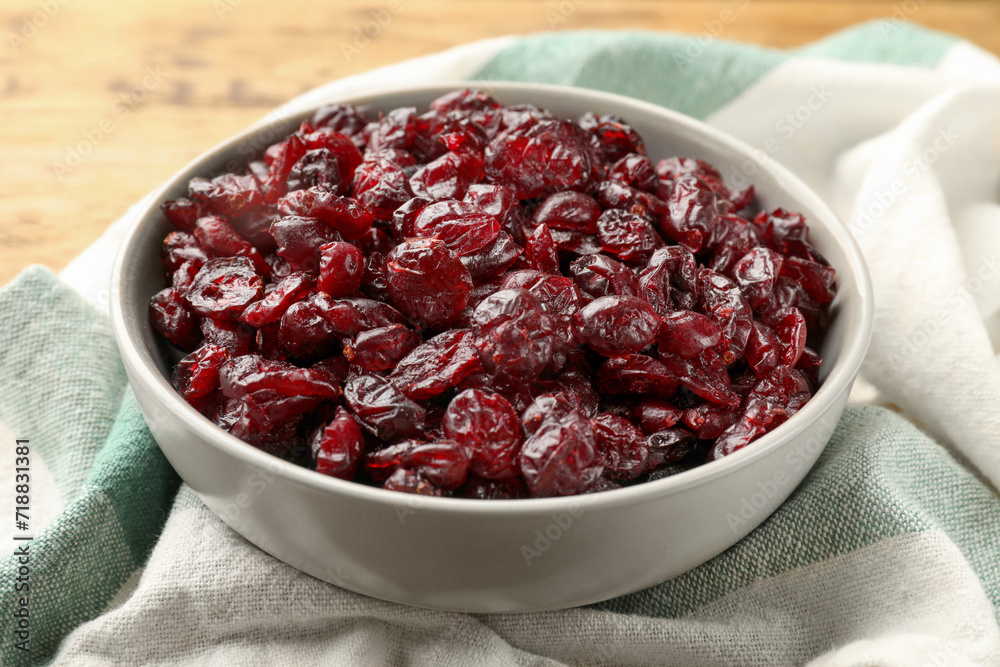 Tasty dried cranberries in bowl on wooden table, closeup Tasty dried cranberries in bowl on wooden table, closeup