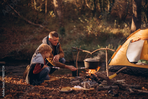 Man and boy tourists autumn time leisure, vacation hiking or traveling touristic activity. Family camping, father and little son relax in forest camp.