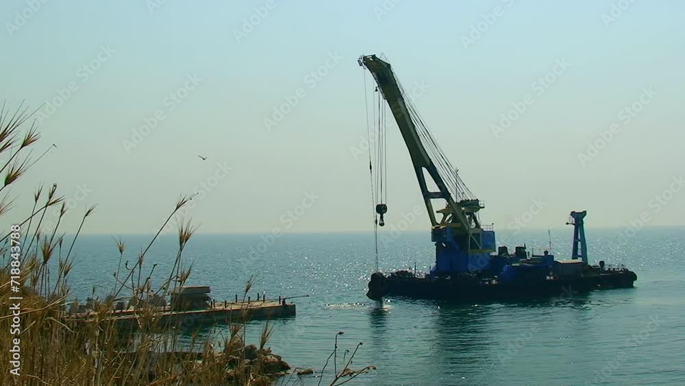 Construction of hydraulic structures, work of a floating crane. Snake Island, Black Sea, Ukraine.