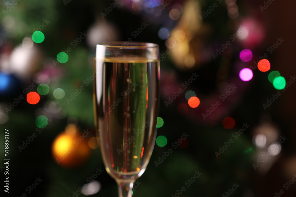 Christmas New Year background with Christmas tree lights and a glass of champagne. Soft focus. Christmas New Year background with Christmas tree lights and a glass of champagne. Soft focus.