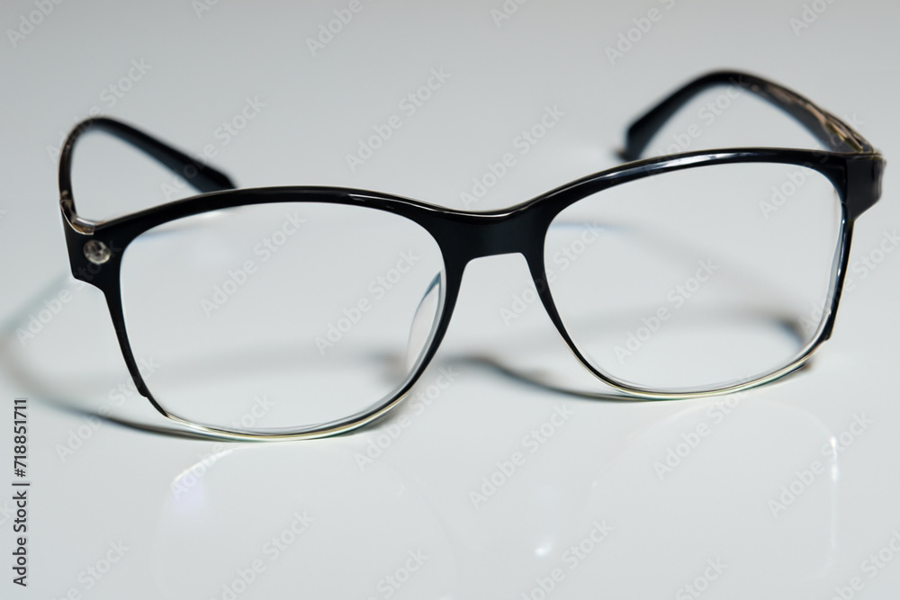 glasses for vision. black square glasses for vision close-up lie on a white table glasses for vision. black square glasses for vision close-up lie on a white table