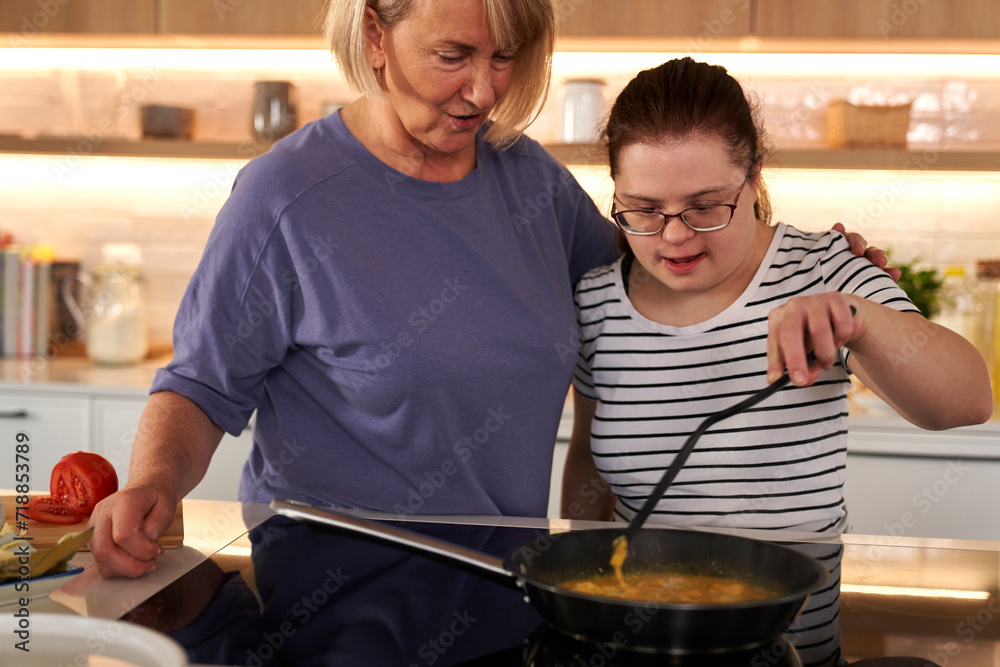 Down syndrome woman and her mother preparing breakfast together