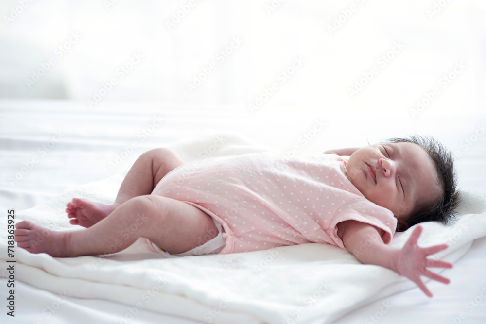 A cute little baby, not yet a month old, lying on bed in bedroom A cute little baby, not yet a month old, lying on bed in bedroom