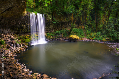 Beaver Falls cascading into a serene pool surrounded by dense forests of Oregon  USA. Long exposure.