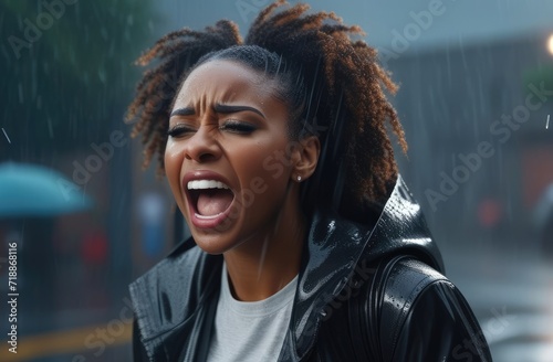 upset black woman screaming, crying at street under rain. shock and emotional breakdown, depression. photo