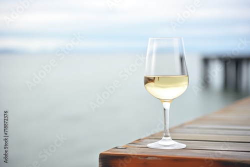 white wine glass with coastal ocean pier in the background