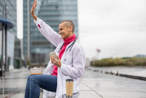 Bild auf Leinwand modern and happy female doctor resting on her lunch break with her cell phone gr