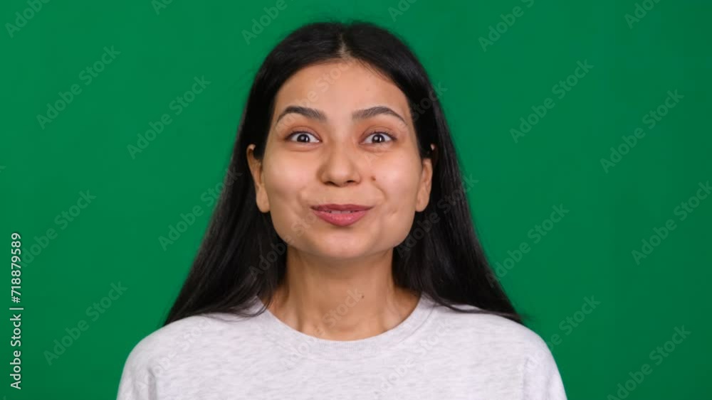 Young woman in a studio portrait, showcasing her amazement and joy with an expression of sheer excitement and wonder, embodying the essence of winning and positive emotion