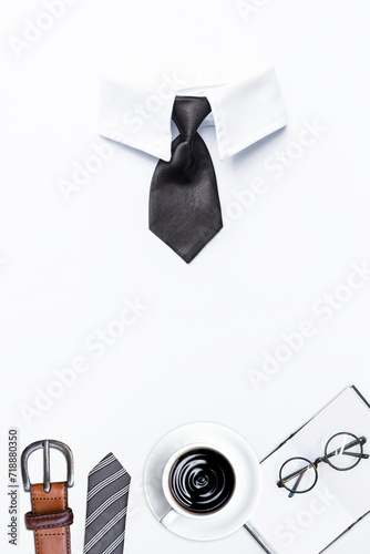 Black necktie with men wear and black coffee with eyeglasses on notebook isolate on white background, business concept background, male beauty and fashion