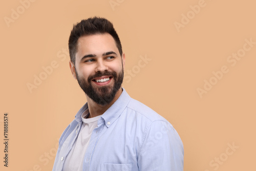 Man with clean teeth smiling on beige background