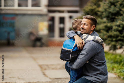 Father and son hugging on kindergarten entrance. photo