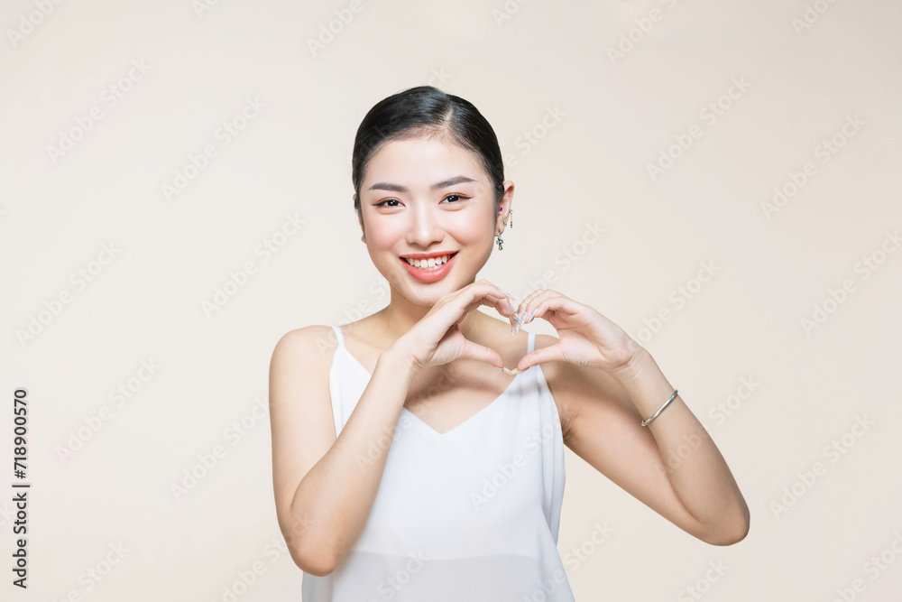 Happy beautiful asian women make heart with her finger near her face Happy beautiful asian women make heart with her finger near her face