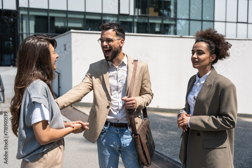 Group of young business people, job candidates standing in front of the office building waiting to be called to meeting with the employer. Businessmen and businesswomen waiting for human resources