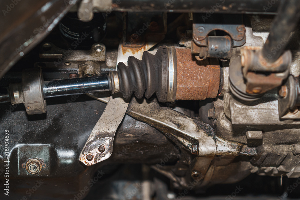 A close-up image of a car's half-shaft on the chassis, showing signs of age and rust.