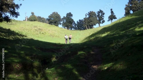 Hikers with backpacks and walking sticks on a Himalayan trek in Naag Tibba, Uttarakhand, India photo