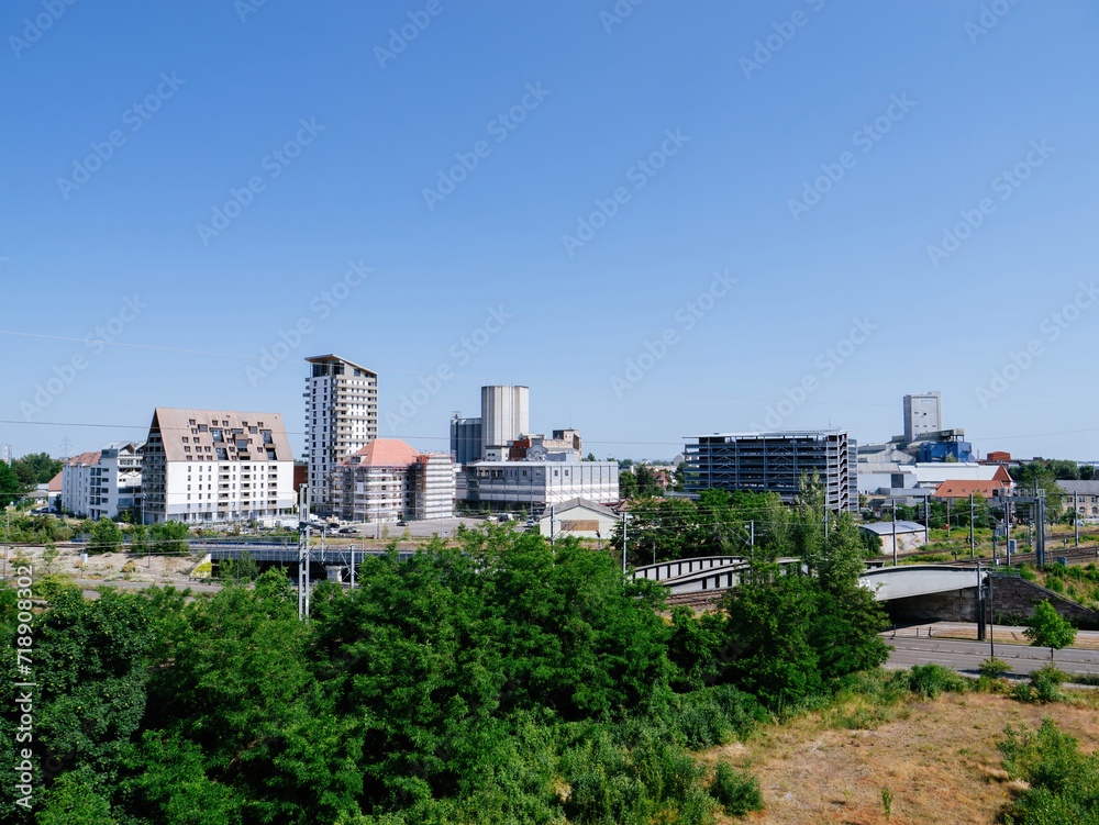 A panoramic view captures the architectural diversity of a bustling Strasbourg city under the tranquil blue sky of a peaceful, sunlit day in Coop neighborhood