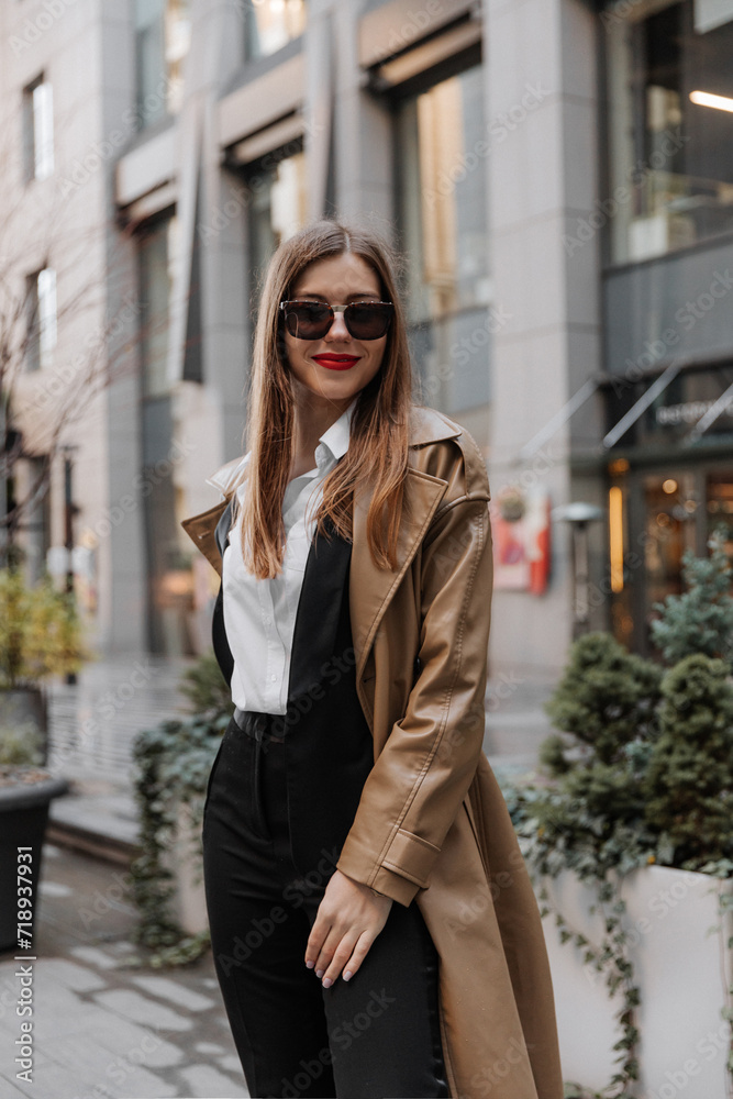 Outdoor portrait of a beautiful young businesswoman in a brown coat at the city Outdoor portrait of a beautiful young businesswoman in a brown coat at the city