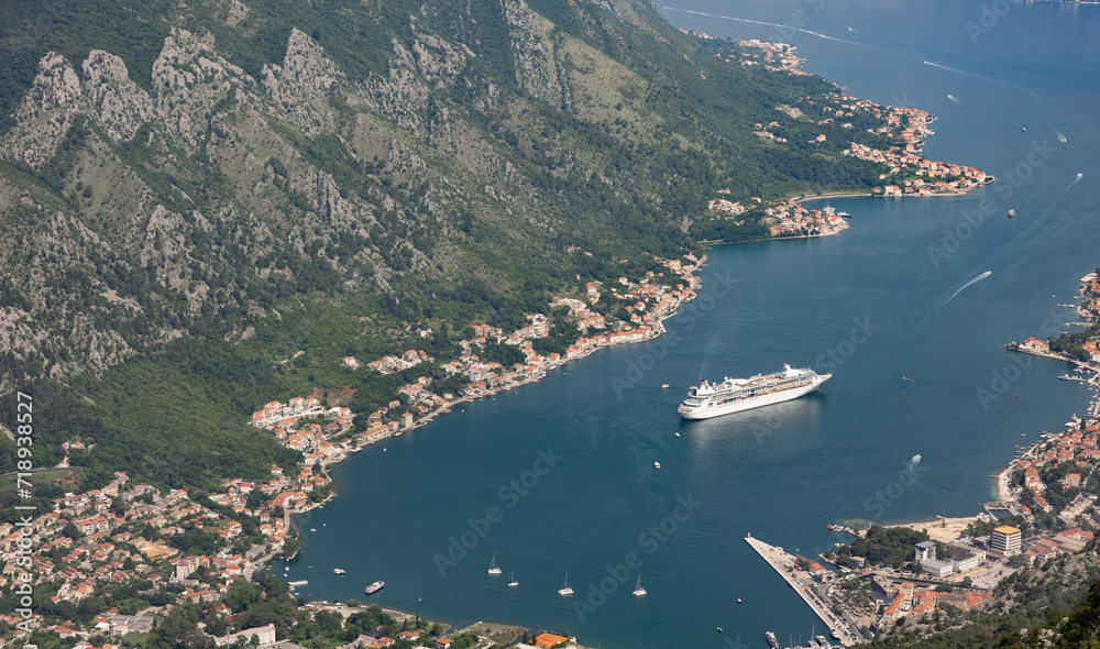 Aerial shot of Kotor bay from the serpentine road in Montenegro. Showing the city's medieval architecture, the Adriatic blue sea water and ships going in outside the bay