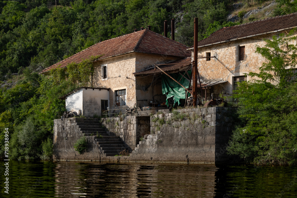 Rijeka Crnojevića, Montenegro - 06 24 2023: Local cabin by the Crnojevića river with a great water view, surrounded by lush green mountains