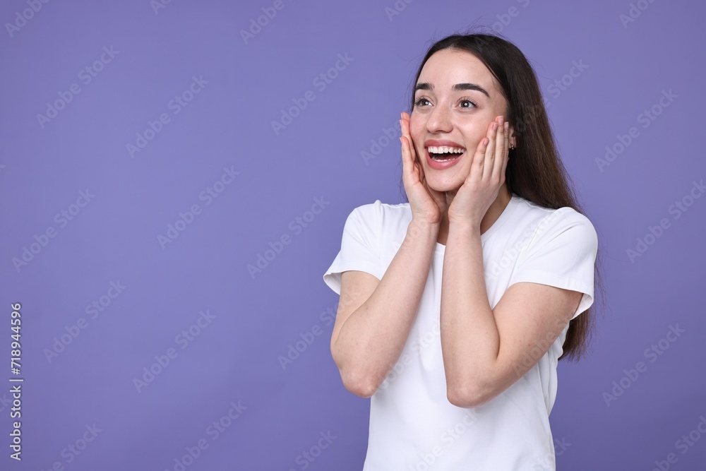 Portrait of happy surprised woman on violet background. Space for text Portrait of happy surprised woman on violet background. Space for text
