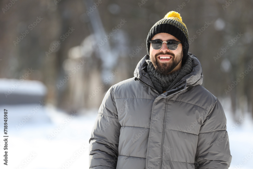 Portrait of handsome young man with sunglasses on winter day outdoors