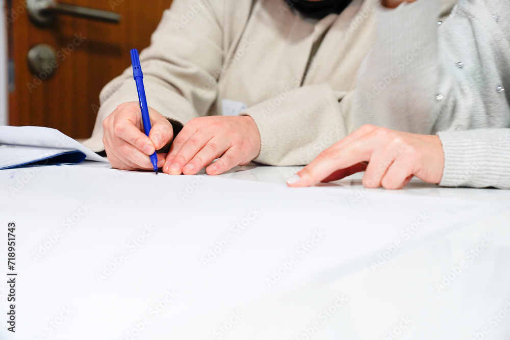 woman writing with pen on paper woman writing with pen on paper