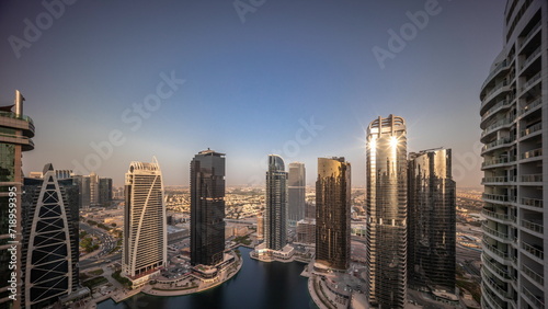 Sunrise over tall residential buildings at JLT aerial all day timelapse photo