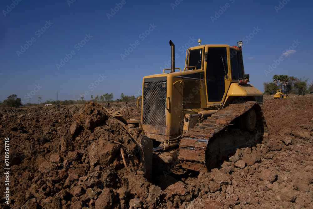 Dozer is pushing dirt. Bulldozer is working  gravel surface for new road.