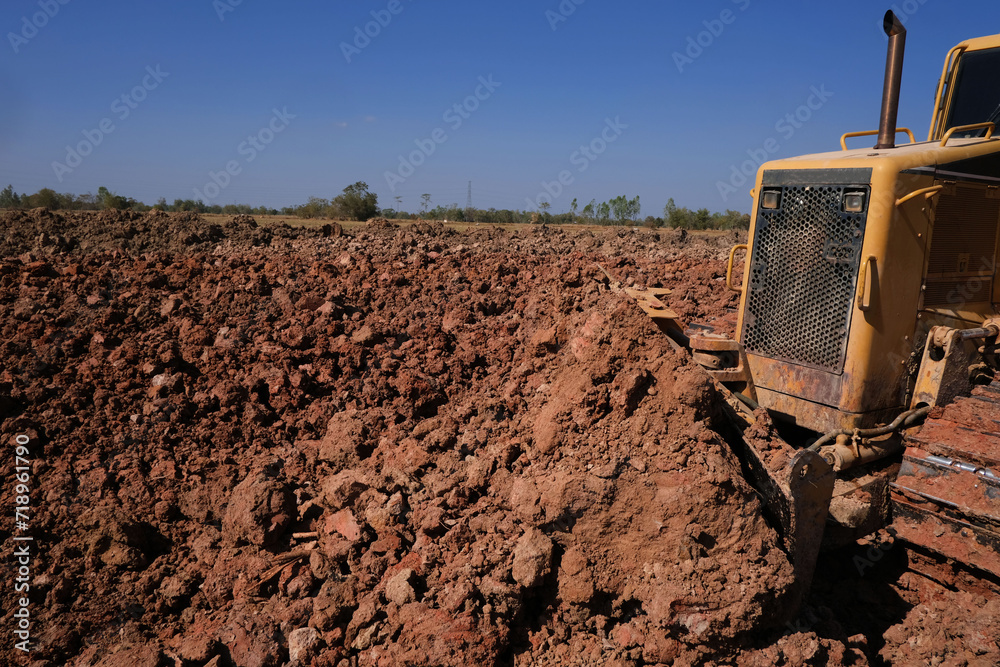 Obraz premium Dozer is pushing dirt. Bulldozer is working gravel surface for new road.