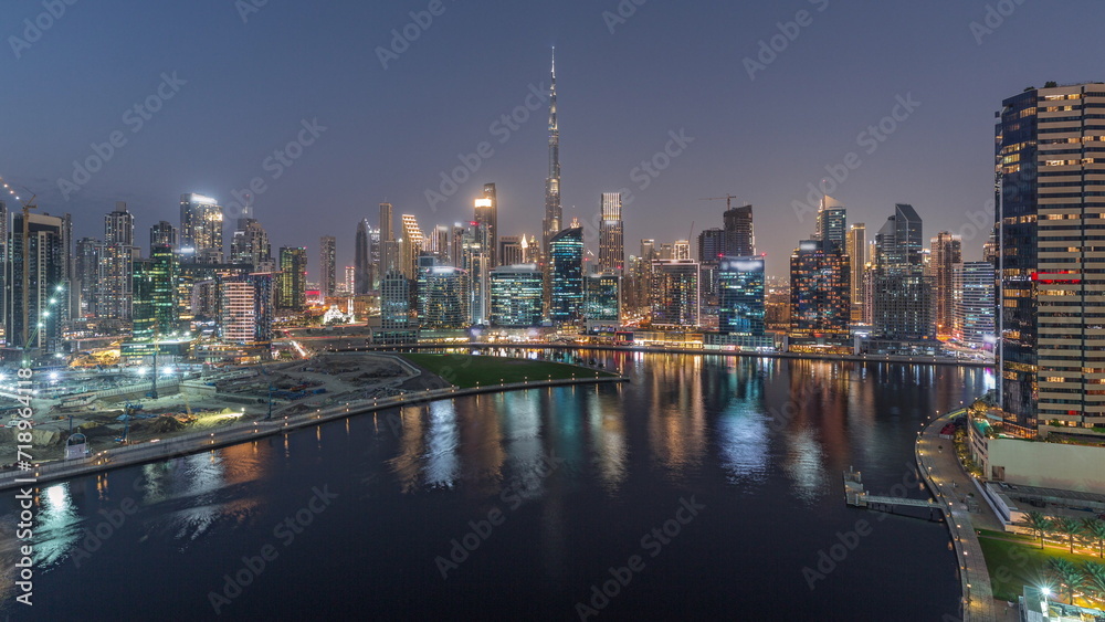 Aerial view to Dubai Business Bay and Downtown with the various skyscrapers and towers day to night timelapse