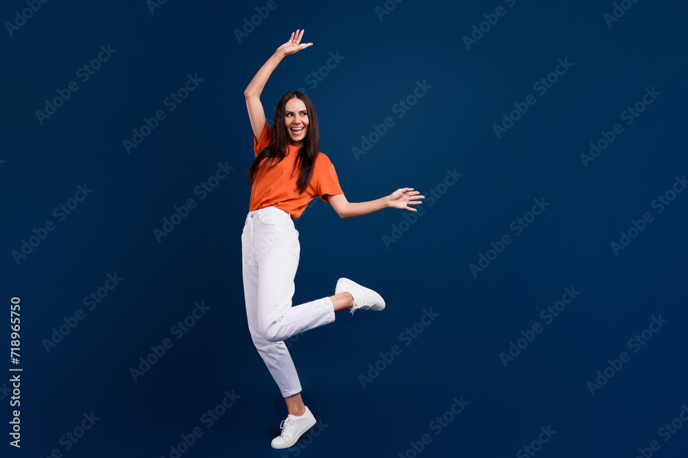 Full length photo of carefree shiny lady wear orange t-shirt having disco fun empty space isolated dark blue color background