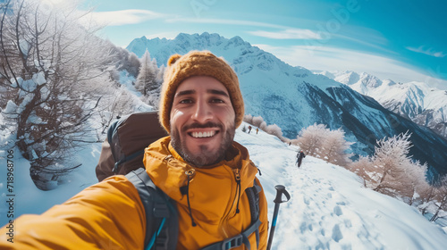 Young man in winter clothes taking selfie on the mountain with snow. Sport and the concept of people
