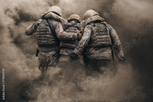 Two army soldiers helping a wounded soldier between smoke and gas in destroyed city