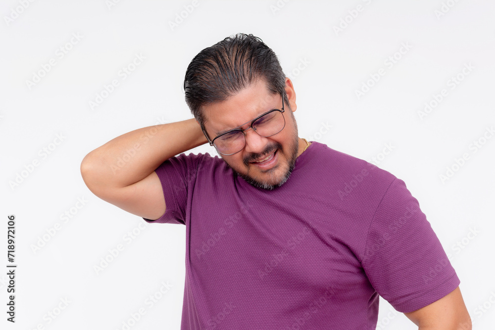 Middle-aged man in glasses exhibits neck pain, holding neck with a grimace of discomfort against a white backdrop. Middle-aged man in glasses exhibits neck pain, holding neck with a grimace of discomfort against a white backdrop.