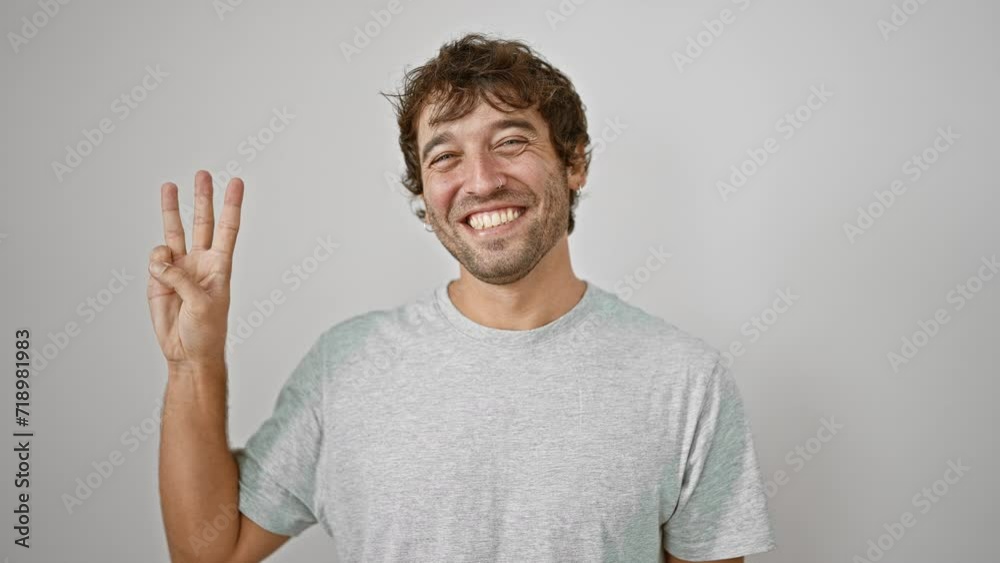 Confident young man, pointing up showing number three with fingers, happy smile brightening up his casual t-shirt look on white isolated background. Confident young man, pointing up showing number three with fingers, happy smile brightening up his casual t-shirt look on white isolated background.