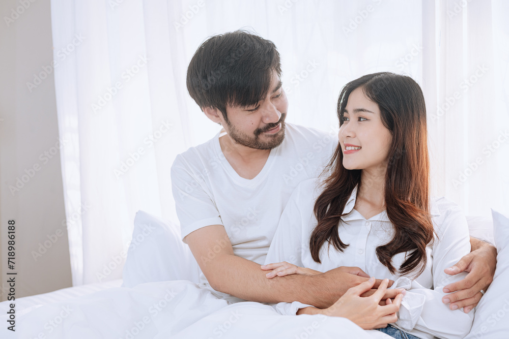 Happy love Asian young man and woman staying together in bedroom, Valentine's Day, Concept of holiday and surprise. Happy love Asian young man and woman staying together in bedroom, Valentine's Day, Concept of holiday and surprise.
