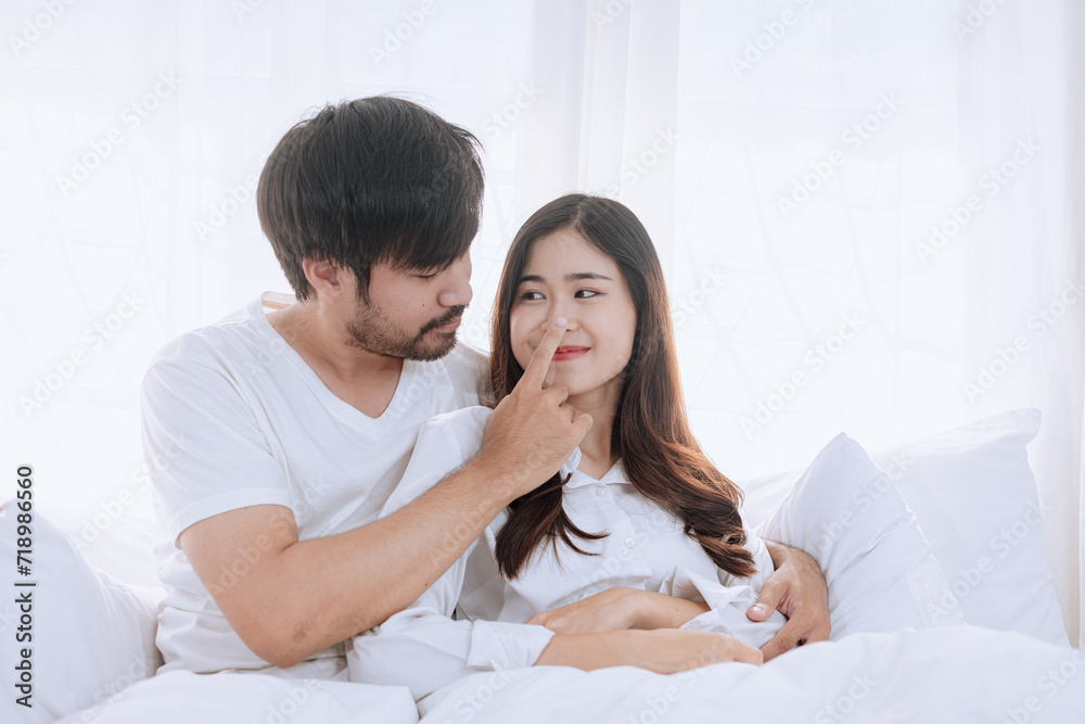 Happy love Asian young man and woman staying together in bedroom, Valentine's Day, Concept of holiday and surprise. Happy love Asian young man and woman staying together in bedroom, Valentine's Day, Concept of holiday and surprise.