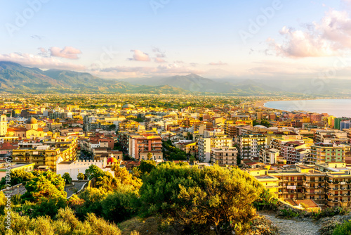 panoramic summer travel view from a hill to beautiful sea coast historical town with port, amazing ocean bay and gulf and beautiful mountains with scenic sunset on background.